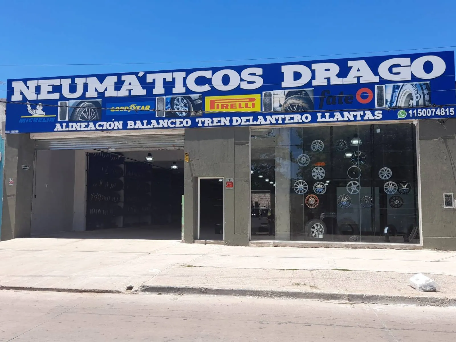 Frente de Neumáticos Drago con el cartel azul sobre la colectora