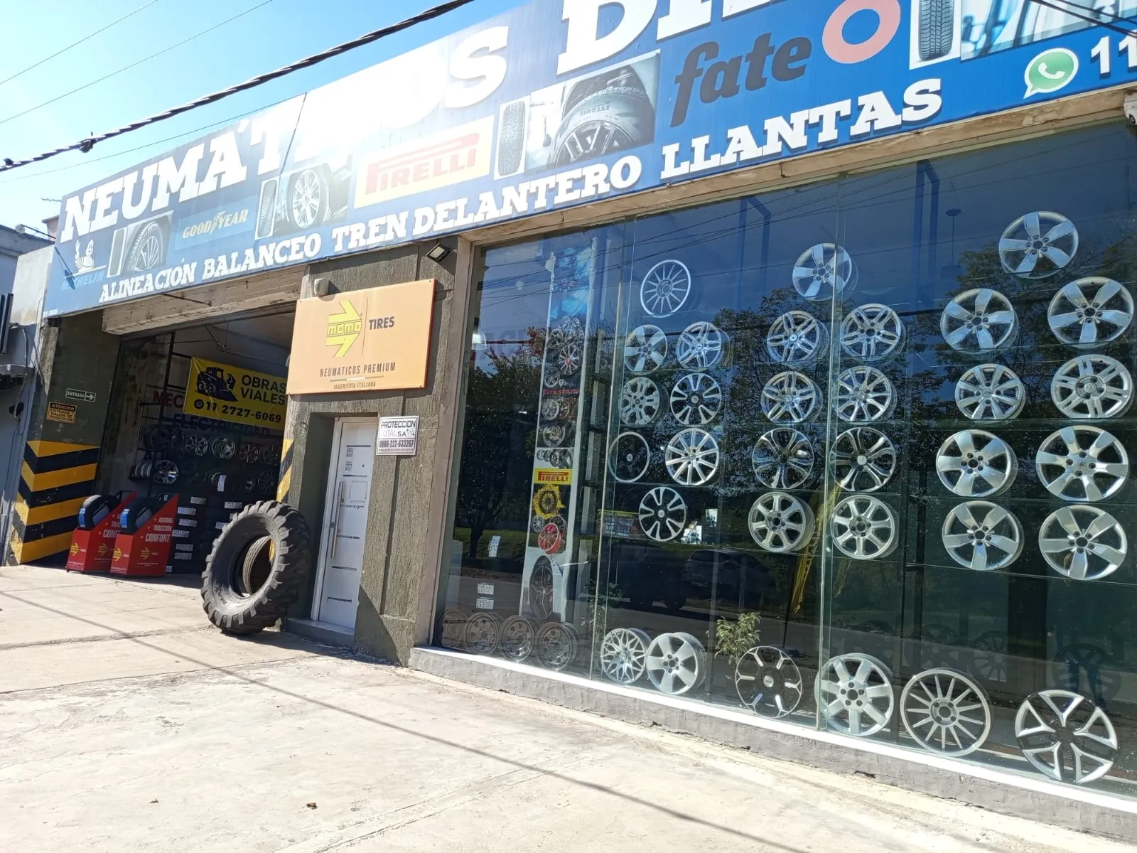 Frente de Neumáticos Drago con la vidriera de llantas y el cartel azul